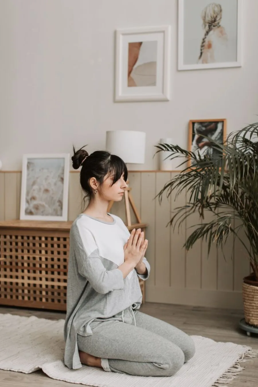 Woman practising quiet meditation in a calm, naturally lit home